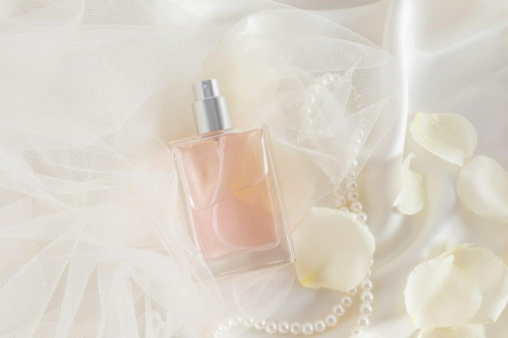 A chic bottle of women's perfume or eau de parfum with a delicate color of cream